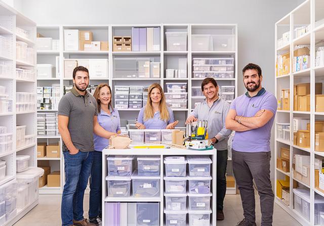 Equipo de asesores de organización del hogar mostrando sistemas de estanterías y contenedores en un showroom amplio y luminoso en Ciudadela, Buenos Aires